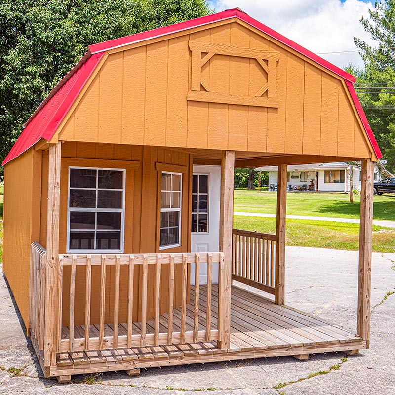 The Deluxe Lofted Cabin with Red Roof, Bay-style windows and white front door.